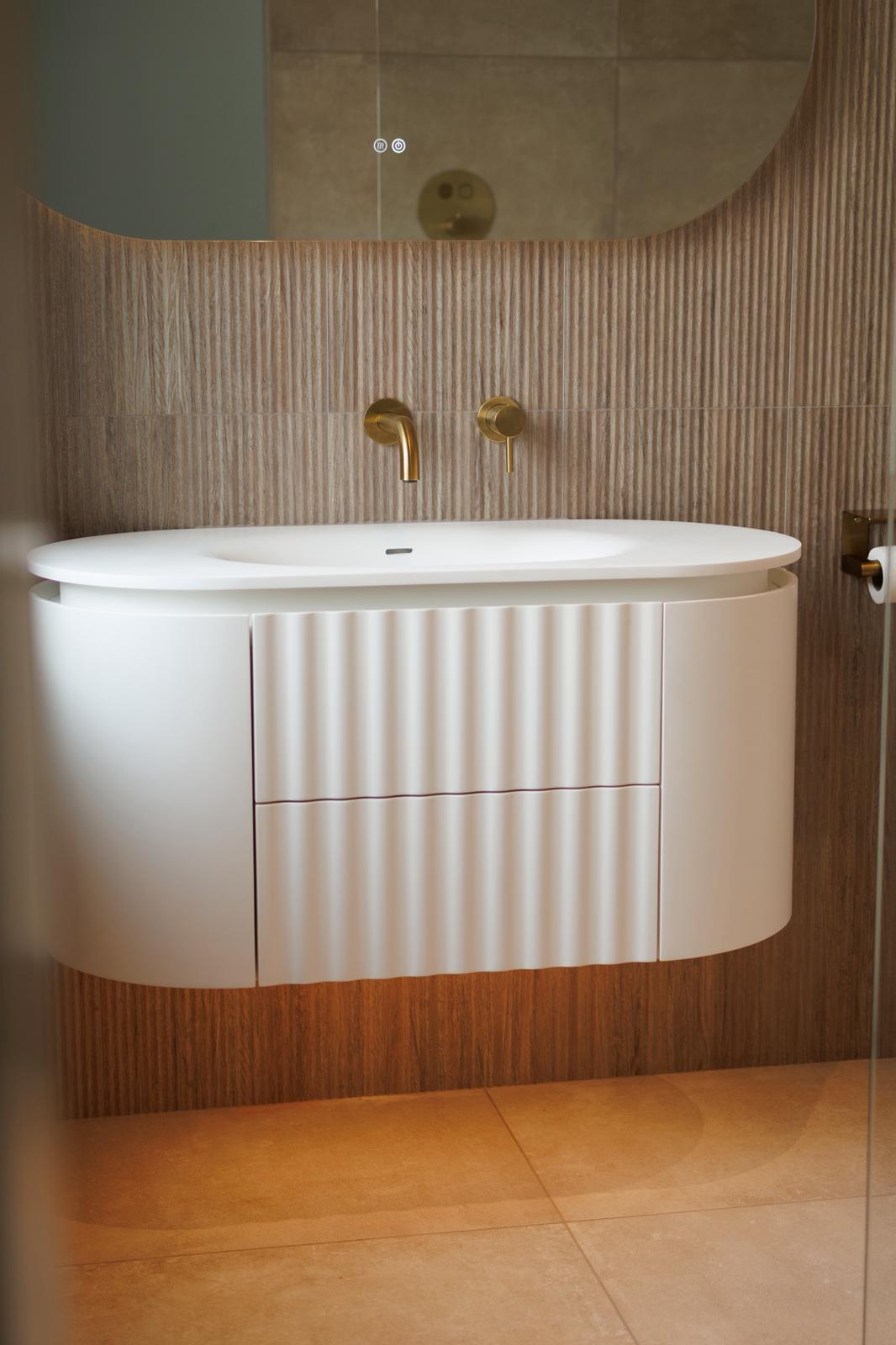 Curved floating vanity with integrated basin
